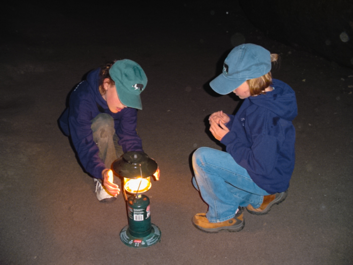 Girl explores in a very dark underground lava tube at Mt St Helens.